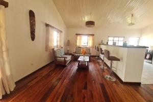 a living room with wood floors and a living room with a table at Villa ASIA in Nosy Be