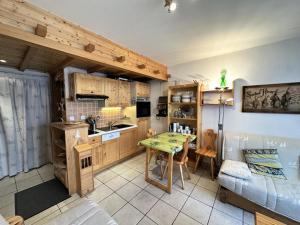 Una cocina y una sala de estar con una mesa y un sofá. en Résidence Les Marmottes - NOUVEAUTE PLEIN CENTRE DU VILLAGE MAE-7861, en Villard-de-Lans