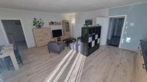 a living room with a couch and a chair and a television at Ferienwohnung Zum Pflanzgarten in Herresbach