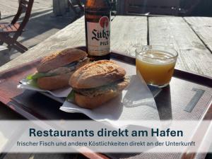 two sandwiches and a glass of beer on a table at Peenemünde, Fewo OG in Peenemünde +20 photos
