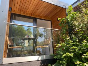 a house with a glass balcony with a table and chairs at The Wee Cabin in Brighton & Hove