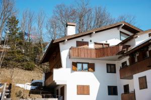 un edificio bianco con balconi in legno di Villa Franchetti - Stayincortina a Cortina dʼAmpezzo