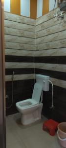 La salle de bains est pourvue de toilettes et d'un mur en bois. dans l'établissement Maa Sharda Guest House, à Ayodhya