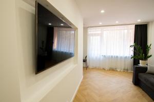 a living room with a large flat screen tv on a wall at Klaipedas apartaments in Liepāja