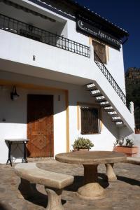 un edificio con banco, mesa y escaleras en La Rueda Apartamentos Rurales, en Chulilla