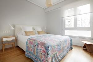 een witte slaapkamer met een bed en een raam bij Palacio Miramar by FeelFree Rentals in San Sebastian