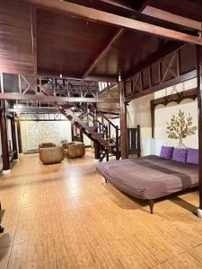 Großes Zimmer mit einem Bett und einer Treppe in der Unterkunft Mangga Bali Bungalow - 23 in Uluwatu