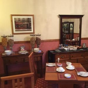 a dining room with two tables and a mirror at Dionard Guest House in Inverness