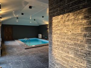 a swimming pool in a room with a brick wall at Champêtre Park View Apartments in Riga