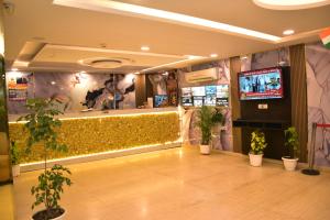a lobby with potted plants and a flat screen tv at BH Hotels Tripper Near IGI Airport in New Delhi