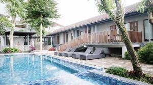 a swimming pool in front of a house at Proven Living in Bandung