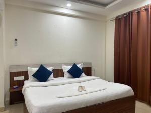 a bedroom with a large bed with blue pillows at Hotel Comfort Inn in Gurgaon +11 photos