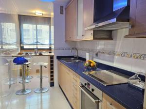 a kitchen with wooden cabinets and a blue counter top at PISO EN EL CENTRO DE NIGRAN CERCA DE PLAYA AMERICA in Nigrán