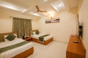 ein Hotelzimmer mit zwei Betten und einem Fenster in der Unterkunft Hotel Grand Galaxy T nagar in Chennai