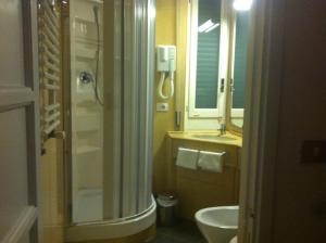 bagno con lavandino, servizi igienici e specchio di Hotel Pensione Moderna a Bonassola