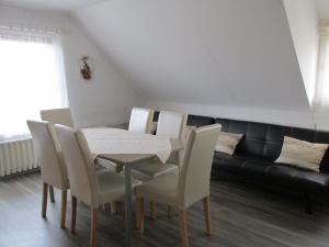 a dining room with a table and chairs and a couch at Betti Vendégház in Alsópáhok
