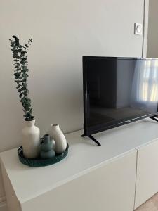 a flat screen tv sitting on top of a white dresser at Grand studio cosy - A deux pas de la gare in Agen