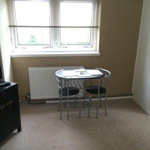 1 mesa y 2 sillas en una habitación con ventana en Kilbarchan Flat, en Kilbarchan