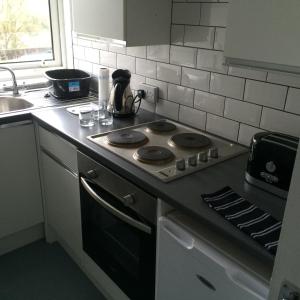 a kitchen counter with a stove and a sink at Kilbarchan Flat in Kilbarchan