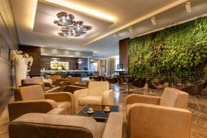 a lobby with a bar with a green wall at Klima Hotel Milano Fiere in Milan