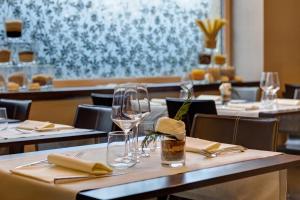 a restaurant with tables with wine glasses and napkins at Klima Hotel Milano Fiere in Milan