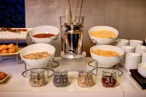 a buffet with bowls and jars of food on a counter at Klima Hotel Milano Fiere in Milan