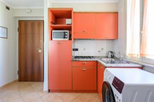 kuchnia z pomarańczowymi szafkami i pralką w obiekcie Crosti Apartments w Rzymie +27 zdjęć
