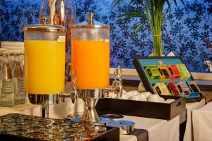 two pitchers of orange juice sitting on top of a stove at Klima Hotel Milano Fiere in Milan