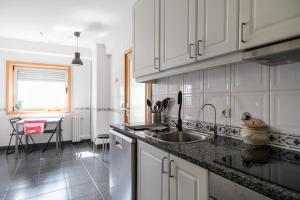 a kitchen with white cabinets and a sink at Beach&Golf - EcoHost - T2 com estacionamento, perto da praia e golf em Vila Nova de Gaia in Arcozelo
