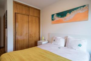 a bedroom with a bed and a wooden door at Gaia Beach&Golf - EcoHost in Arcozelo