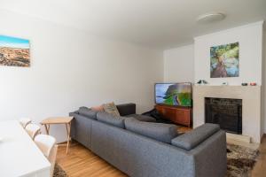 a living room with a couch and a fireplace at Gaia Beach&Golf - EcoHost in Arcozelo