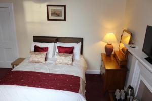 
a bedroom with a bed and a lamp at Brackness House Luxury B&B in Anstruther
