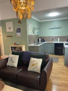 a living room with a couch and a kitchen at Beach House in Lytham St Annes