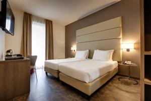 a hotel room with a bed and a television at Klima Hotel Milano Fiere in Milan