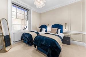 a bedroom with two beds and a mirror at Luxury Living in Bath - The Bridgeton - Sleeps 20 in Bath