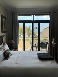 a bedroom with a bed with a view of a patio at 35 Ocean Breeze Winkelspruit in Kingsborough +13 photos