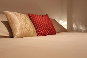 dwie poduszki siedzące na łóżku w obiekcie L'Attico del Centro w mieście Matera