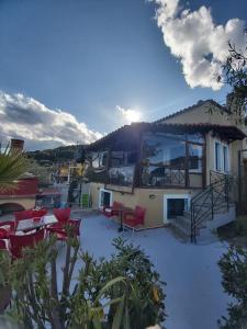 a house with red chairs and a patio at Villa Velika GR in Velika +70 photos