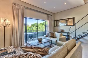a living room with a couch and a table at Heritage Square Apartments in Durbanville