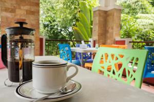 a cup of coffee sitting on a table with a thermos at Villa Alicia in Yogyakarta