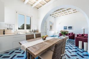 een keuken en eetkamer met een houten tafel en stoelen bij Firriato Hospitality - Calamoni di Favignana Apartments in Favignana