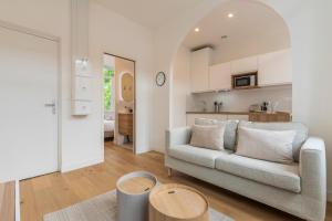 een woonkamer met een bank en een keuken bij Appartement T2 proche tramway et commodités in Tourcoing