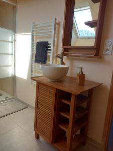 a bathroom with a bowl sink on a wooden vanity at Location 24h du Mans in Parigné-lʼÉvêque