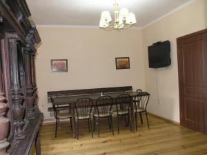 a dining room with a table and chairs and a television at Arnika Tatariv in Tatariv
