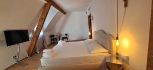 een slaapkamer met een wit bed en een televisie bij Santer Klause in Merano