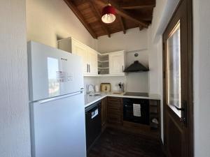 a kitchen with a white refrigerator and a sink at Dual İmroz in Gökçeada