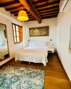 a bedroom with a white bed and a rug at TRUFFLE'N'BED in San Giovanni dʼAsso