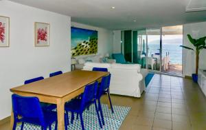 a living room with a table and blue chairs at Casa L’Augusta in Altafulla