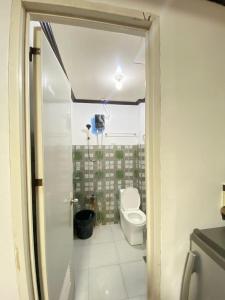 Un pequeño baño con inodoro y ventana. en Chana IAO studio near the Beach, en General Luna