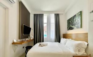 a bedroom with a large white bed and a window at ATAP Hotel in Kota Kinabalu